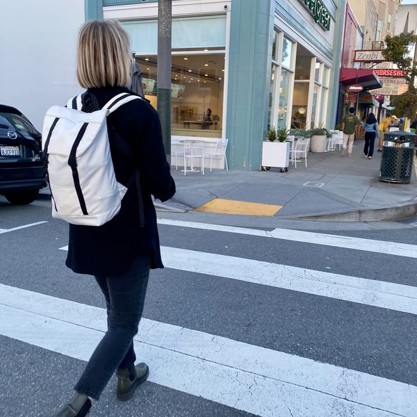 Heather with the Eleven Fifteen Daypack in white walking home from work