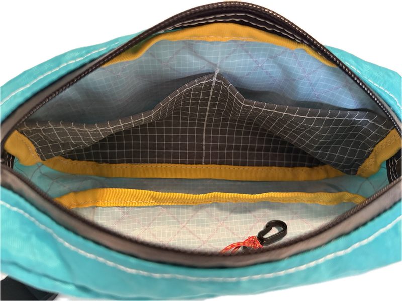 Interior detail of a Towpath Pack in teal, showing inside pocket and key loop
